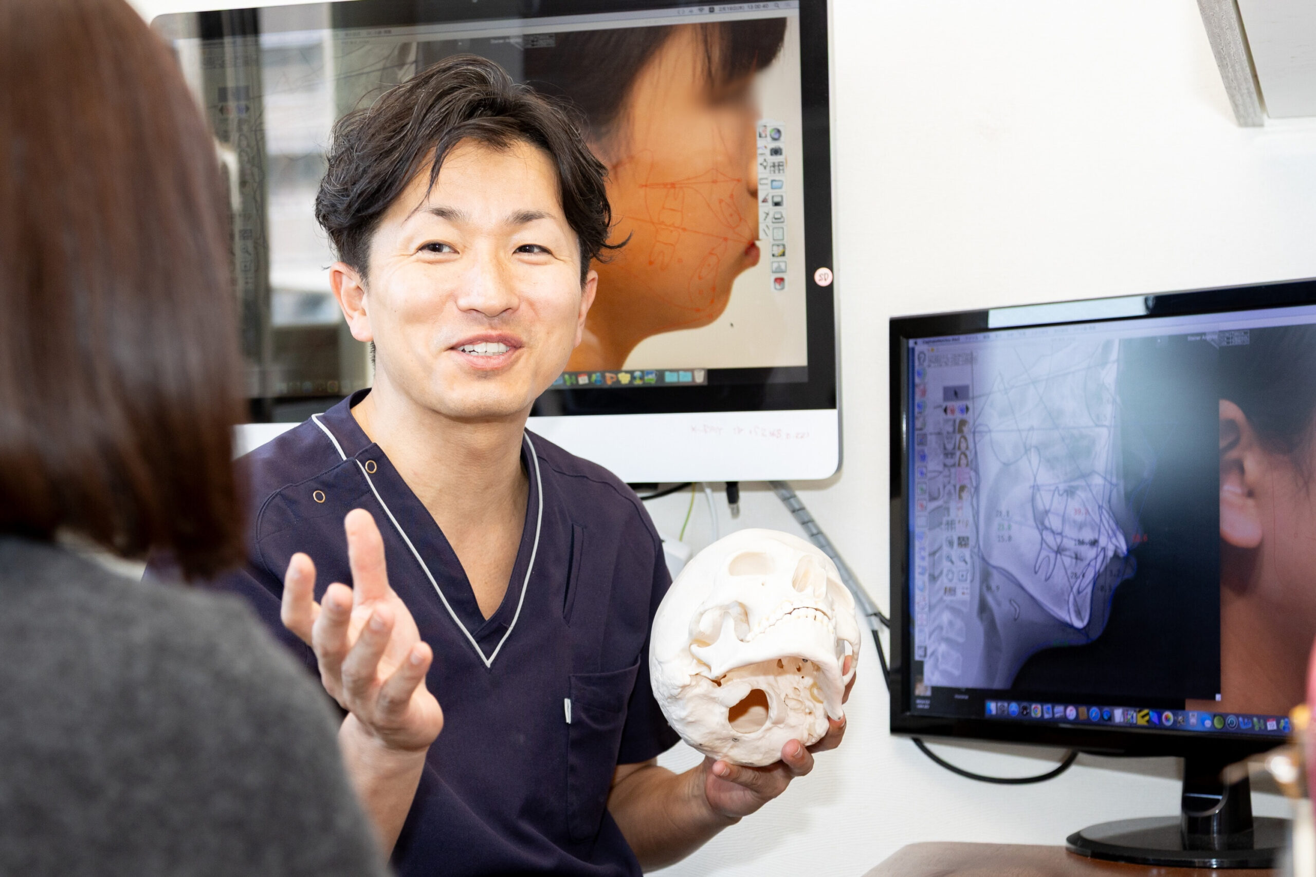 歯科衛生士が診療室で患者に説明を行っている様子