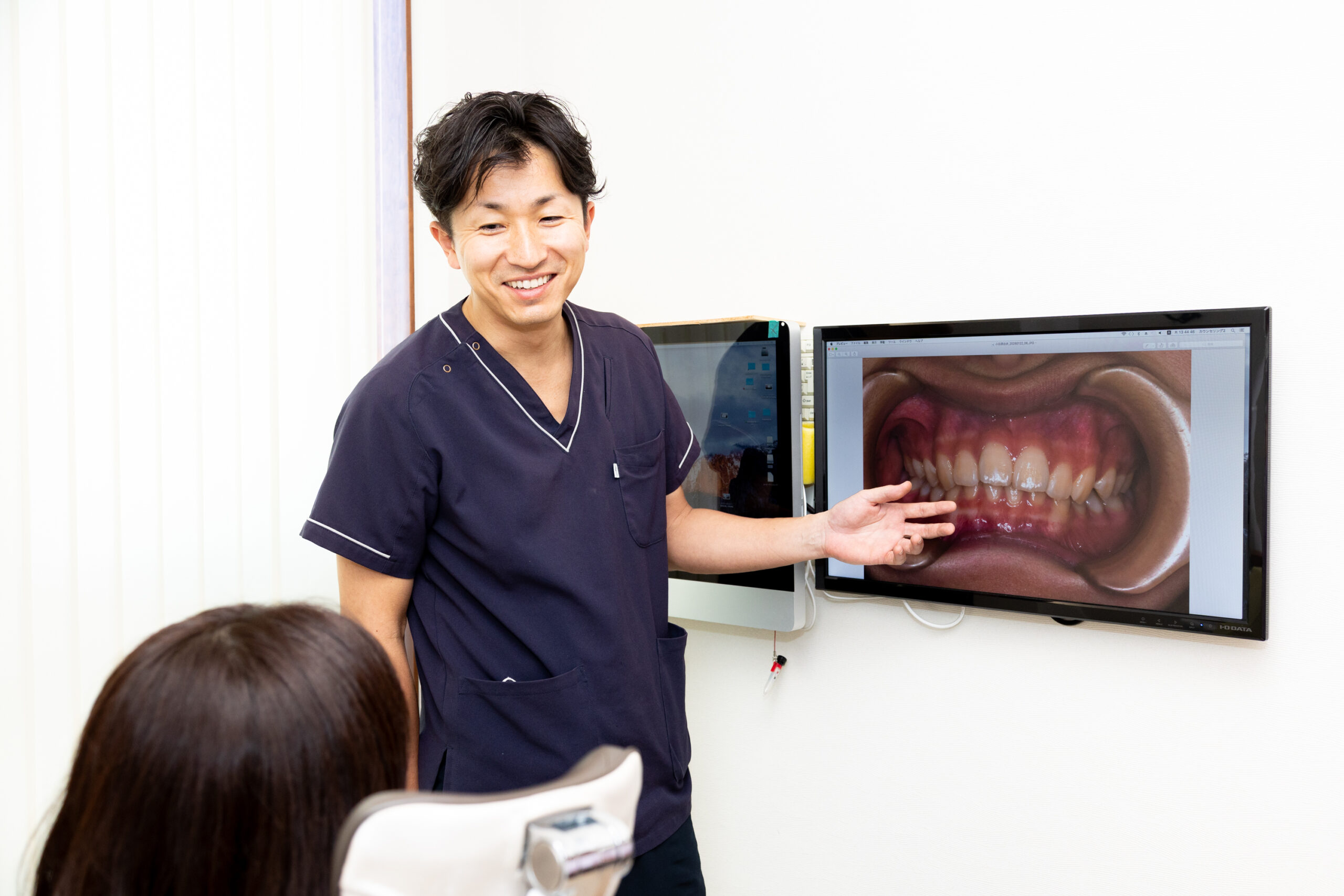 歯科衛生士が診療室で患者に説明を行っている様子