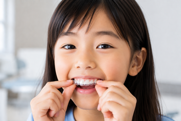 矯正器を調整する笑顔の少女
